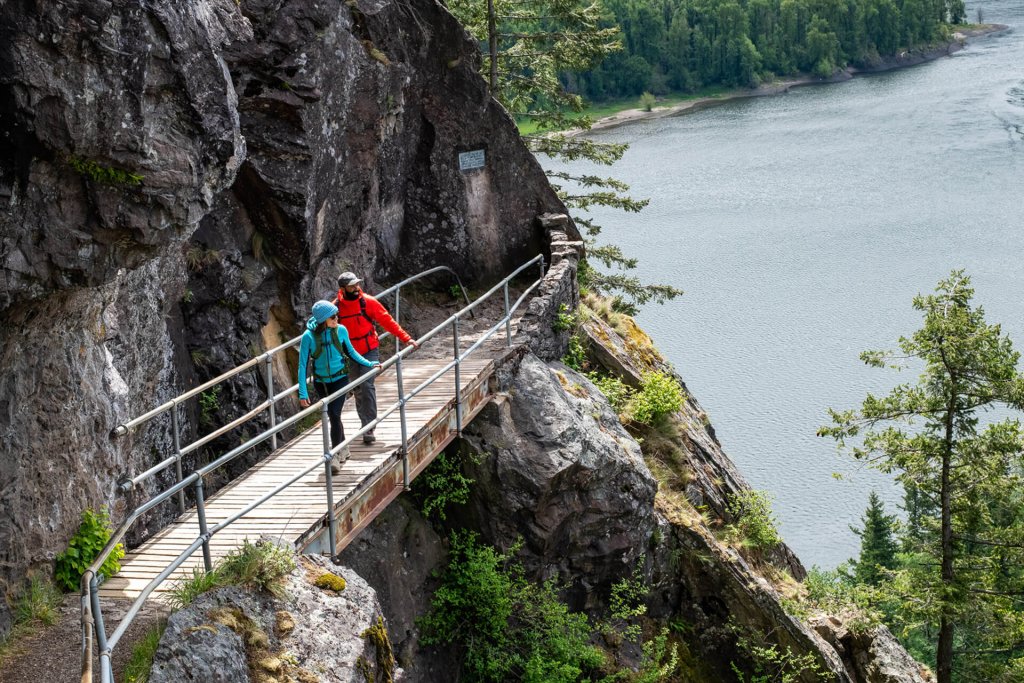 A man and woman walk along a bridge at Beacon Rock State Park, a popular rock climbing destination. 