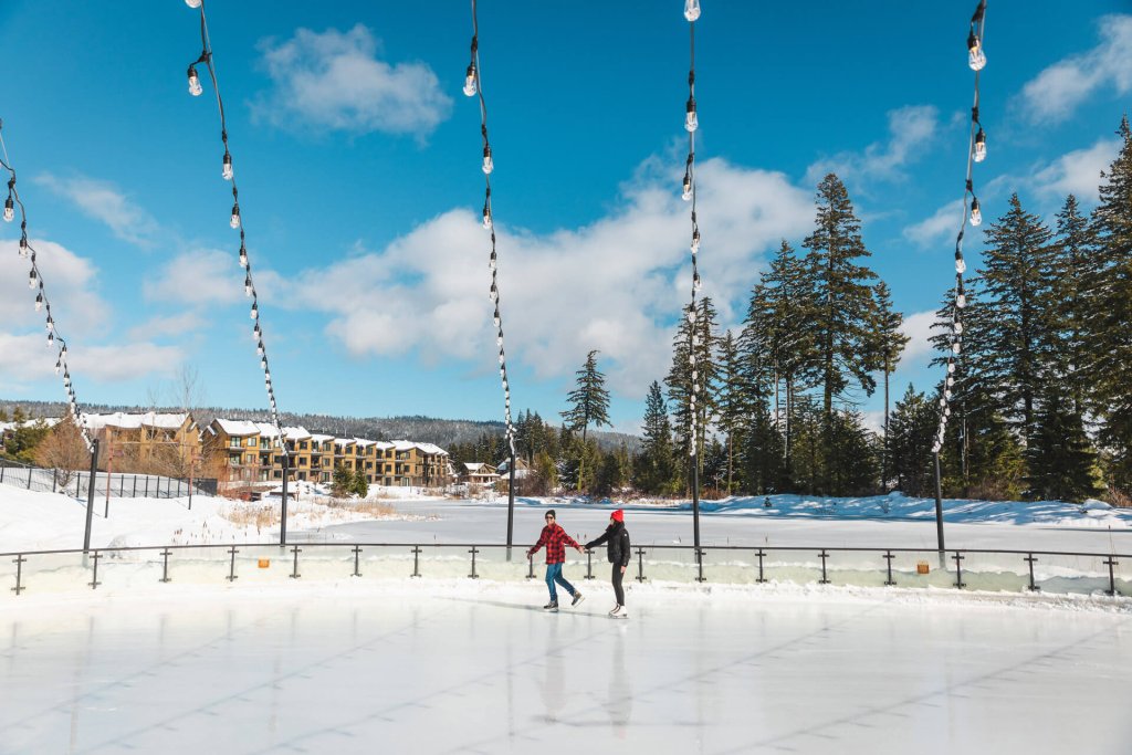 Two people skate in an outdoor ice rink at Suncadia Resort in Washington