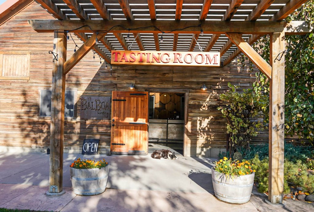 A dog sleeps in front of the door to a tasting room in Walla Walla