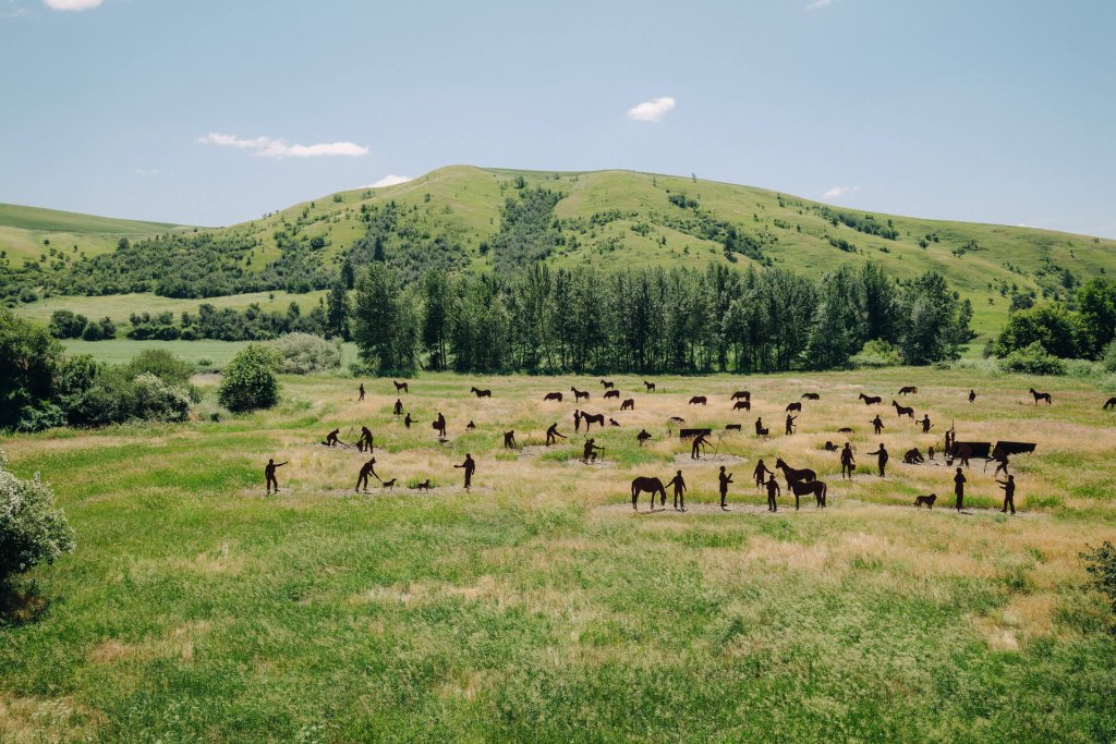 Lifesize metal cutouts depticting people and horses are spread throughout a grass field at Patit Creek Campsite in Eastern Washington.