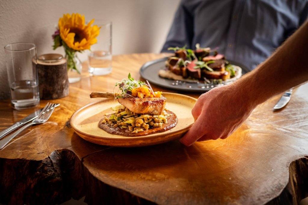 A server sets two plates on a table at Elements restaurant in Vancouver.