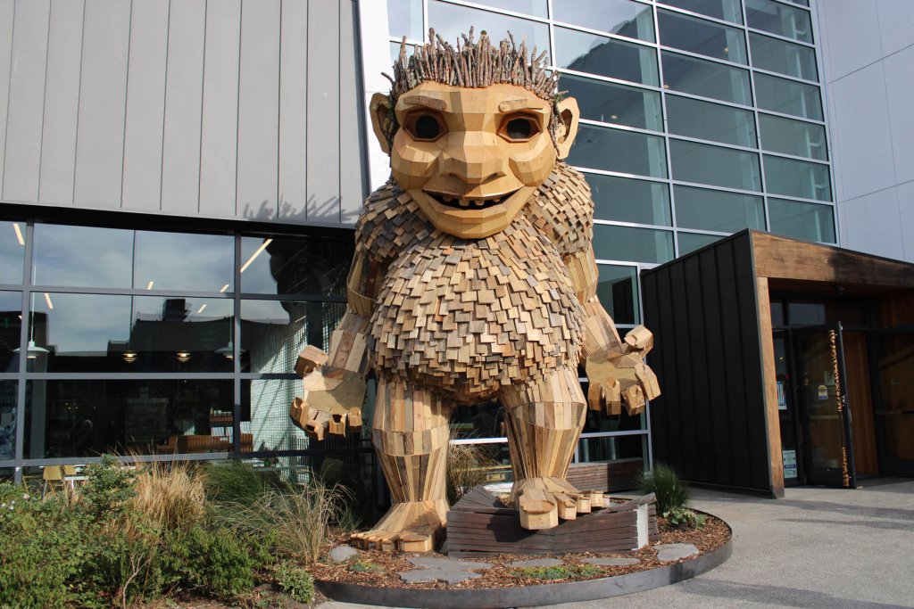 A large wooden troll stands in from of a museum in Washington State 