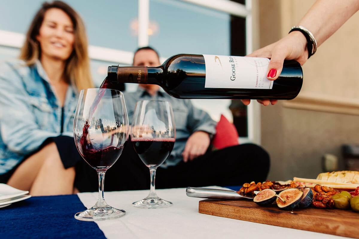 Wine is poured into a glass at an outdoor table at Goose Ridge Estates 