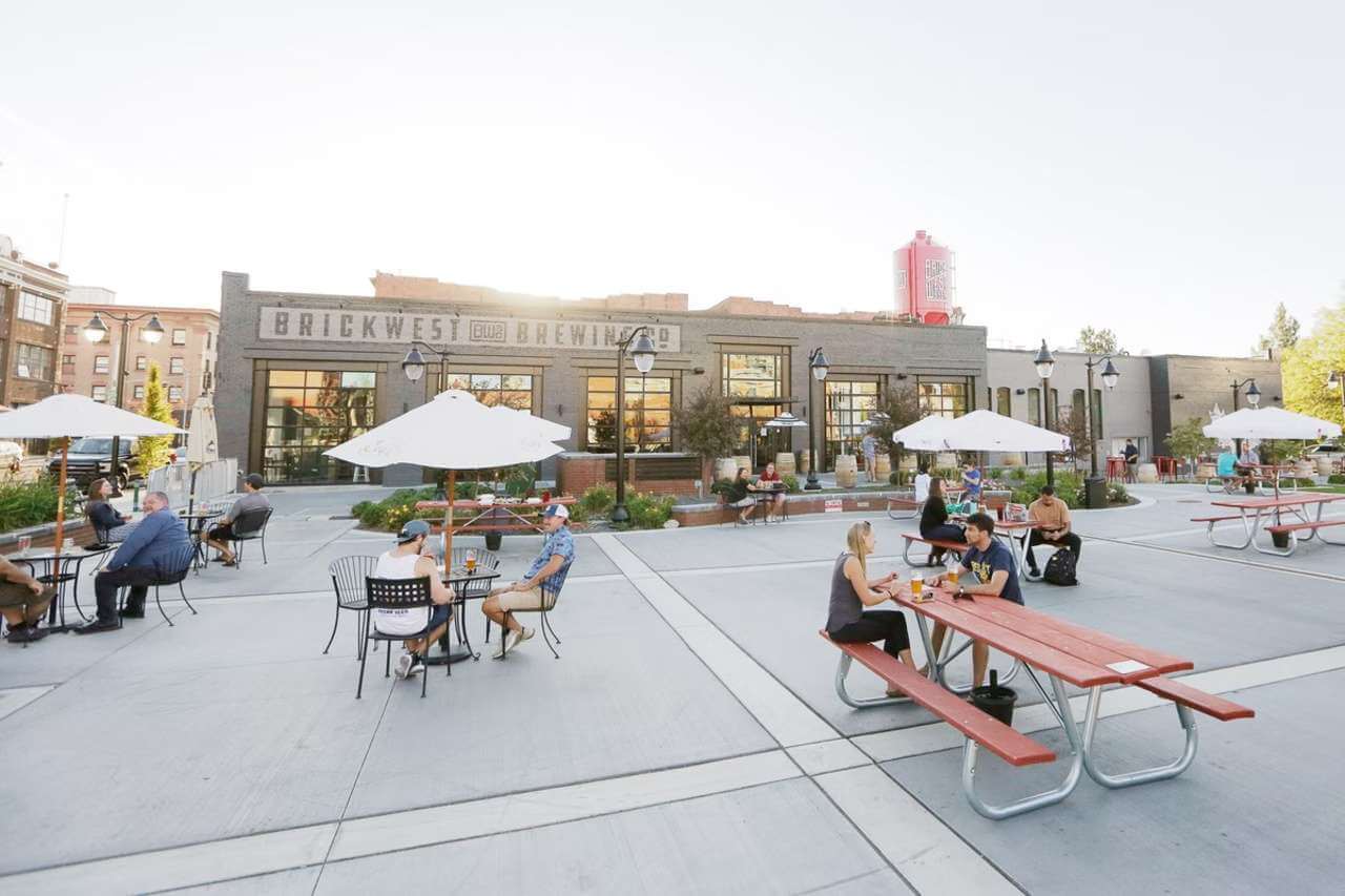 Photo of people sitting at outdoor picnic tables at a brewery in Spokane