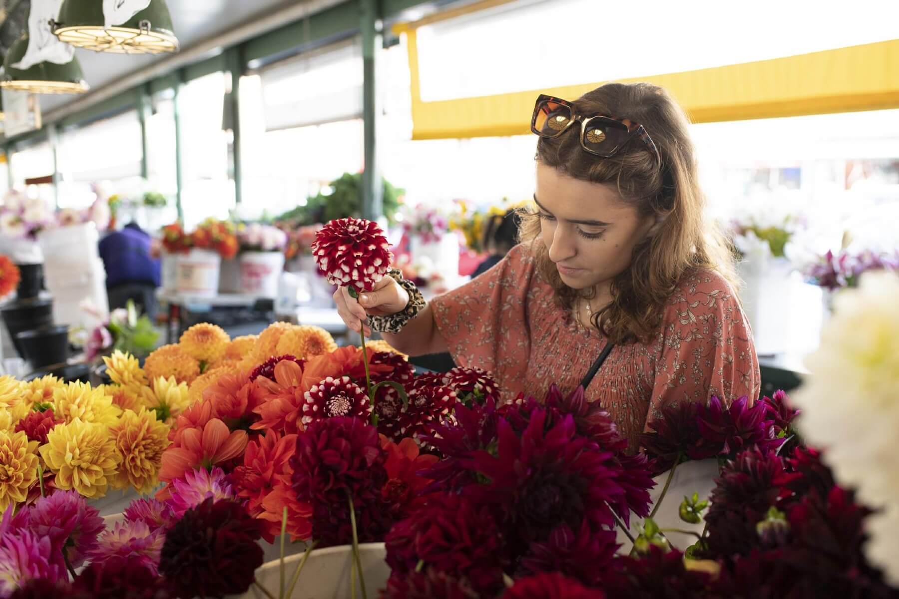 A woman shops for flowers at Pike Place Market in Seattle