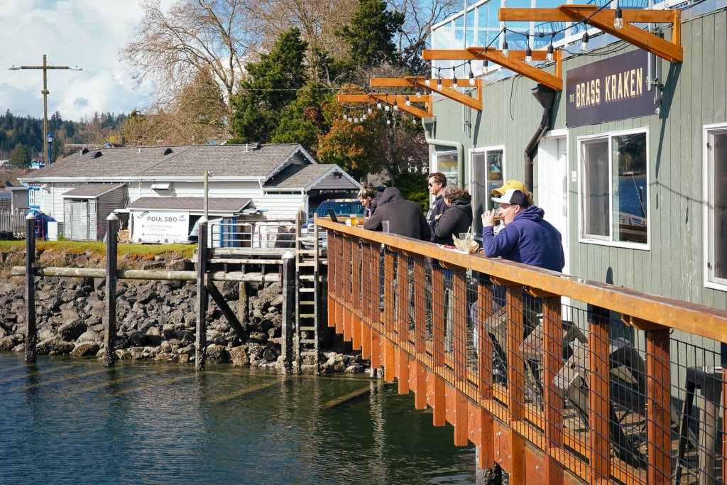 A photo of people dining outside at a restaurant along the water