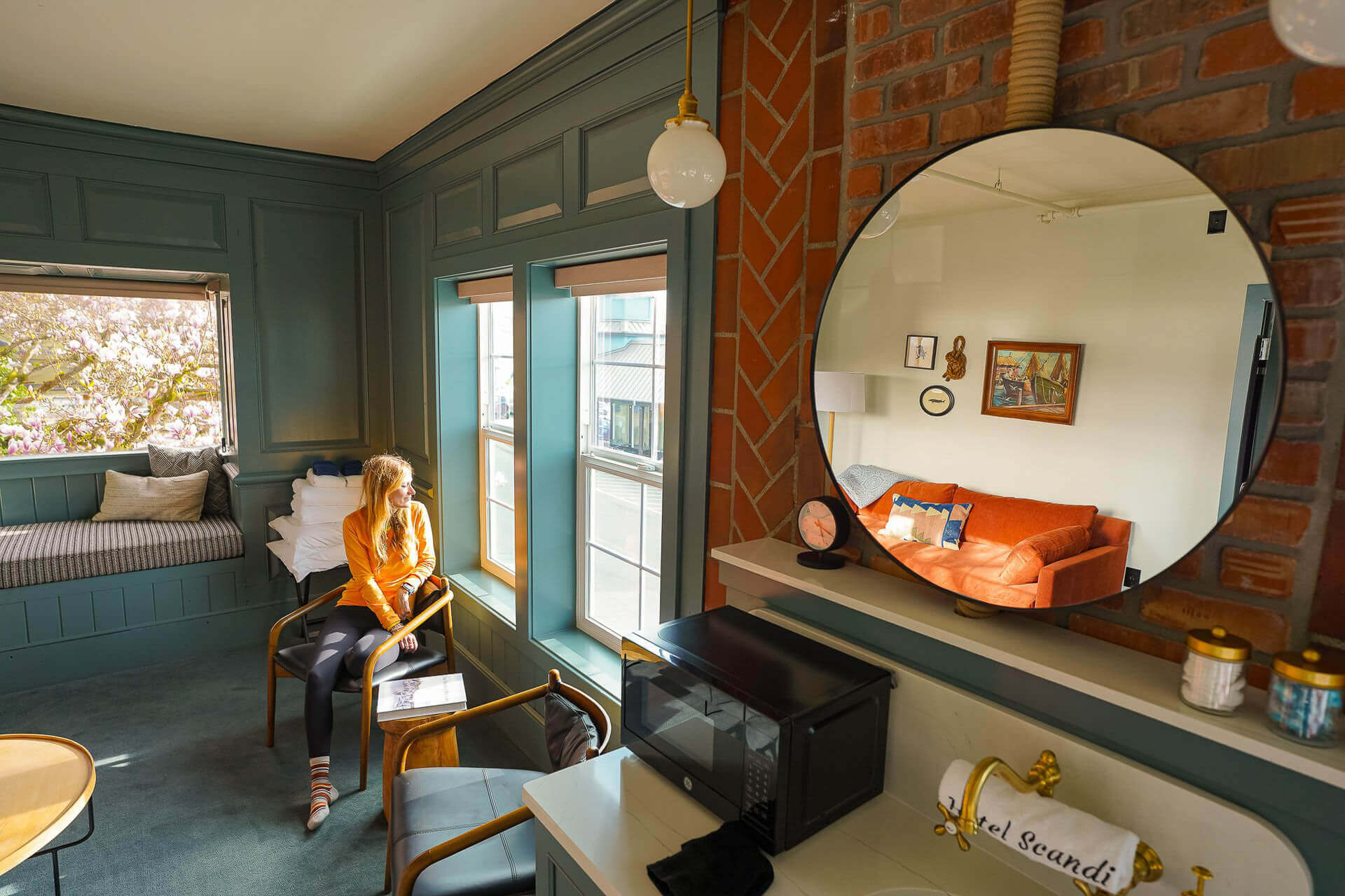 A photo of a woman looking out a window in a hotel room