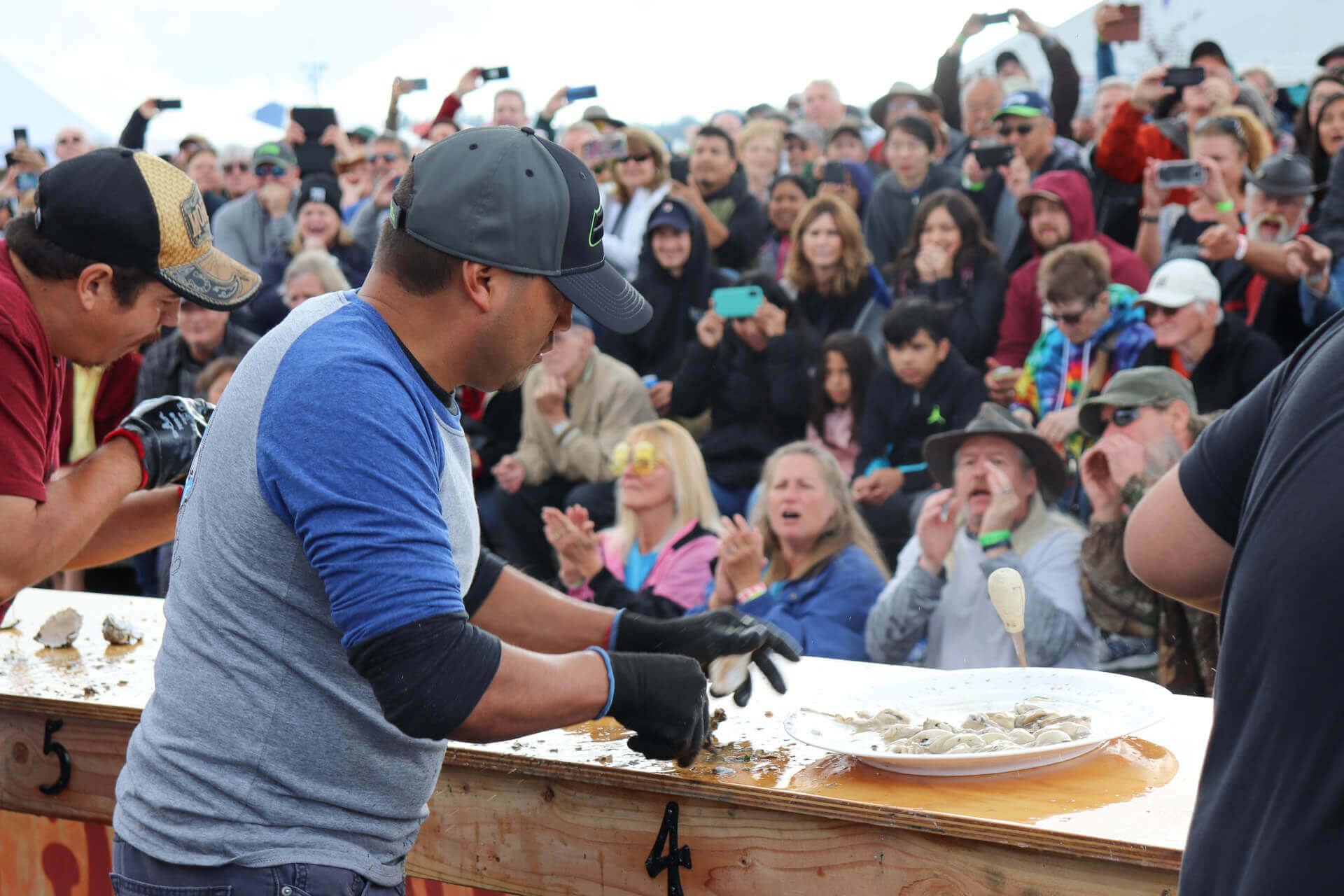 A man shucks fresh oysters at a food festival in washington