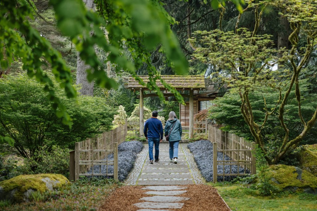 A man and woman walk along a garden path at the Bloedel Reserve on Bainbridge Island