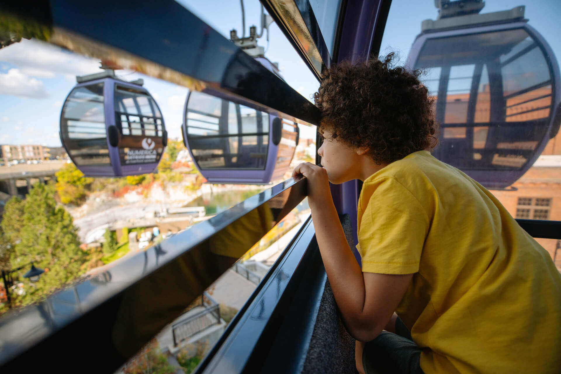 A young boy looks out of the skyride gondola in Spokane Falls. 