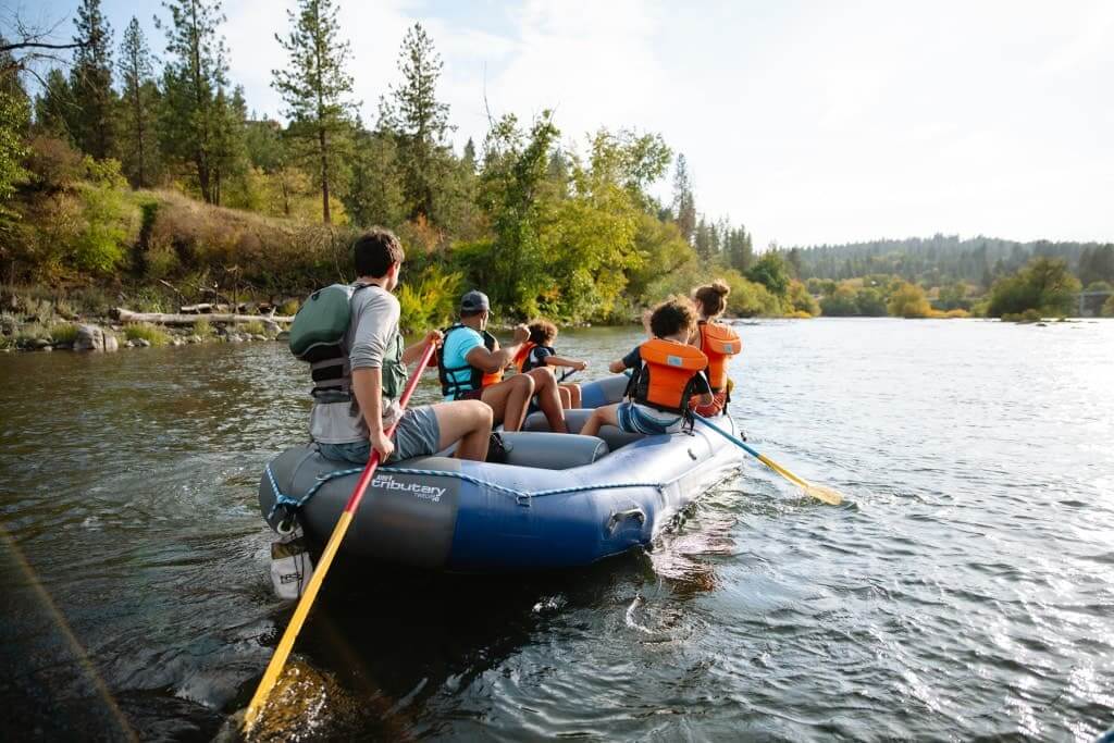 A family paddles together in a raft.