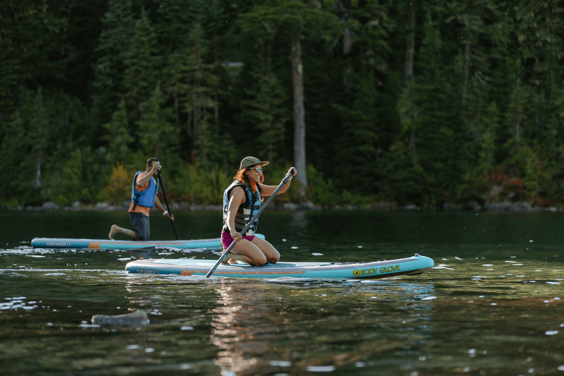 A couple paddle boarding in Mount Rainier National Park in Washington State. 